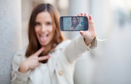 Beautiful young woman taking a self portrait
